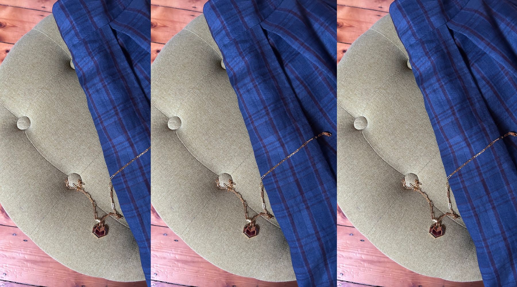 navy check skirt and gold heart necklace with a dark stone, thrown over a green armchair