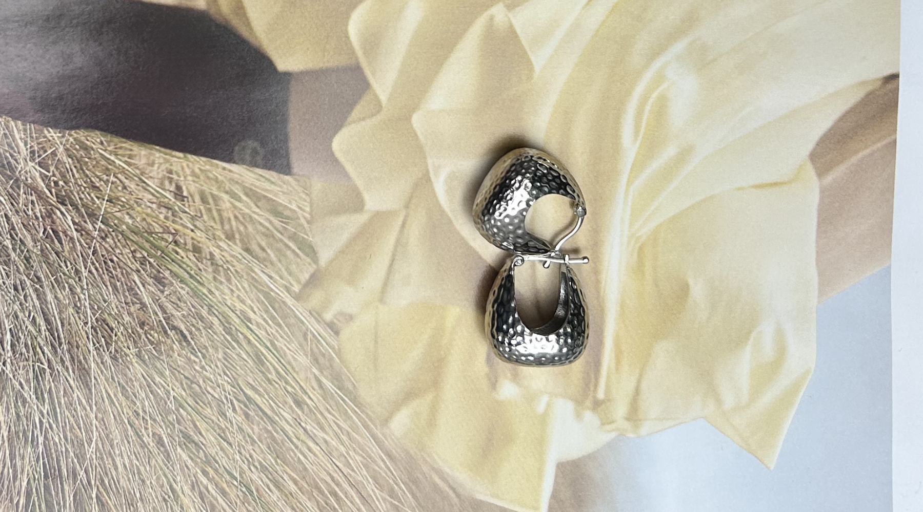 silver large hoop earrings on a yellow and hay background