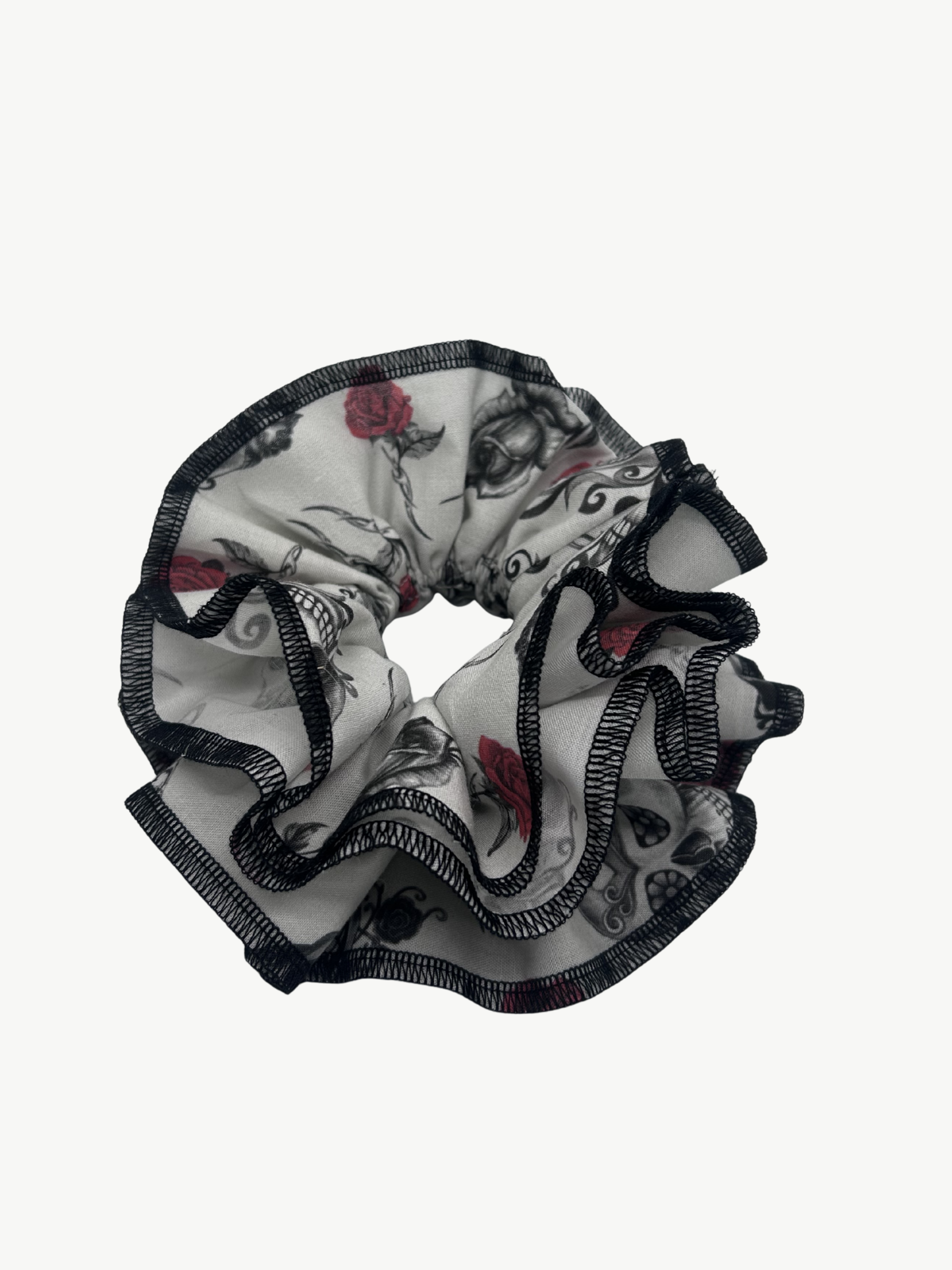 Scrunchie with black and white skull and rose design on a white background