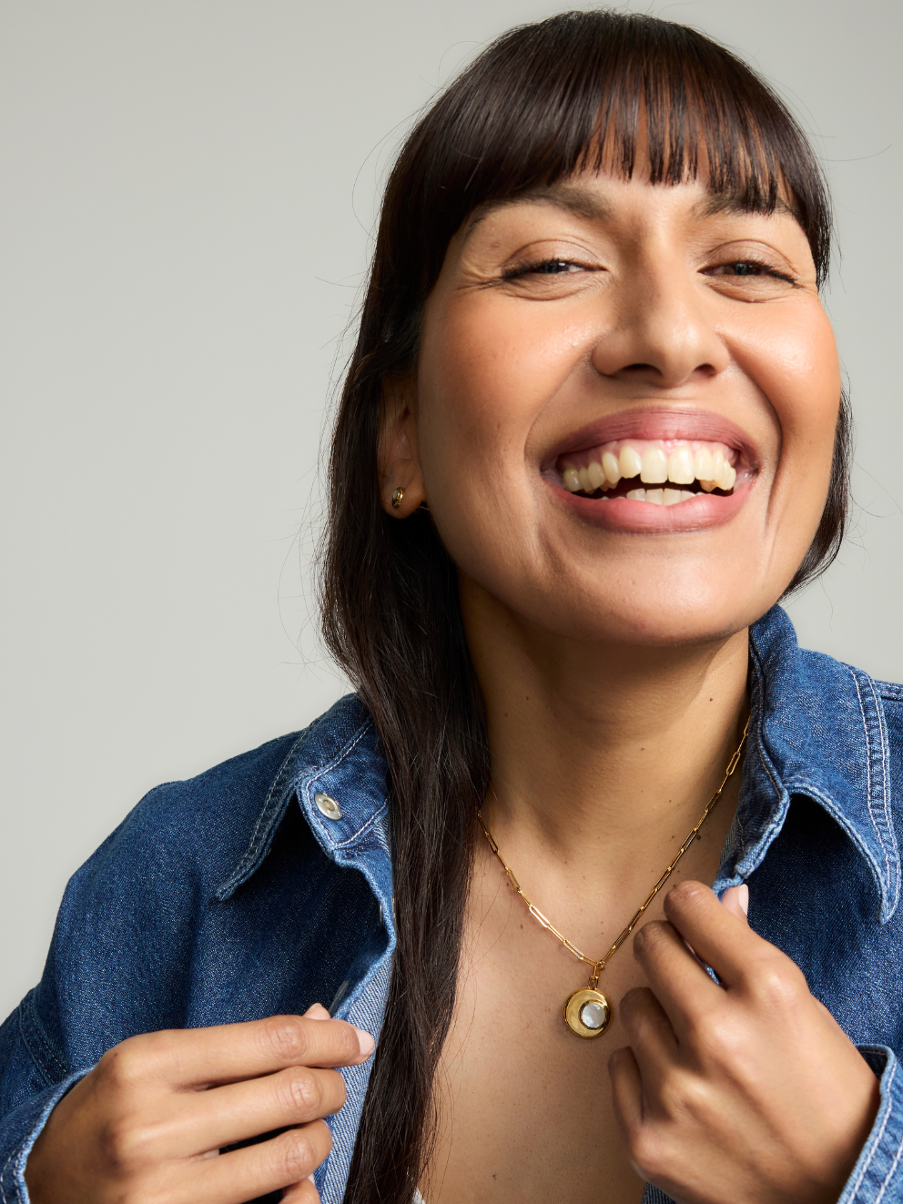 Woman wearing a necklace with a gray background