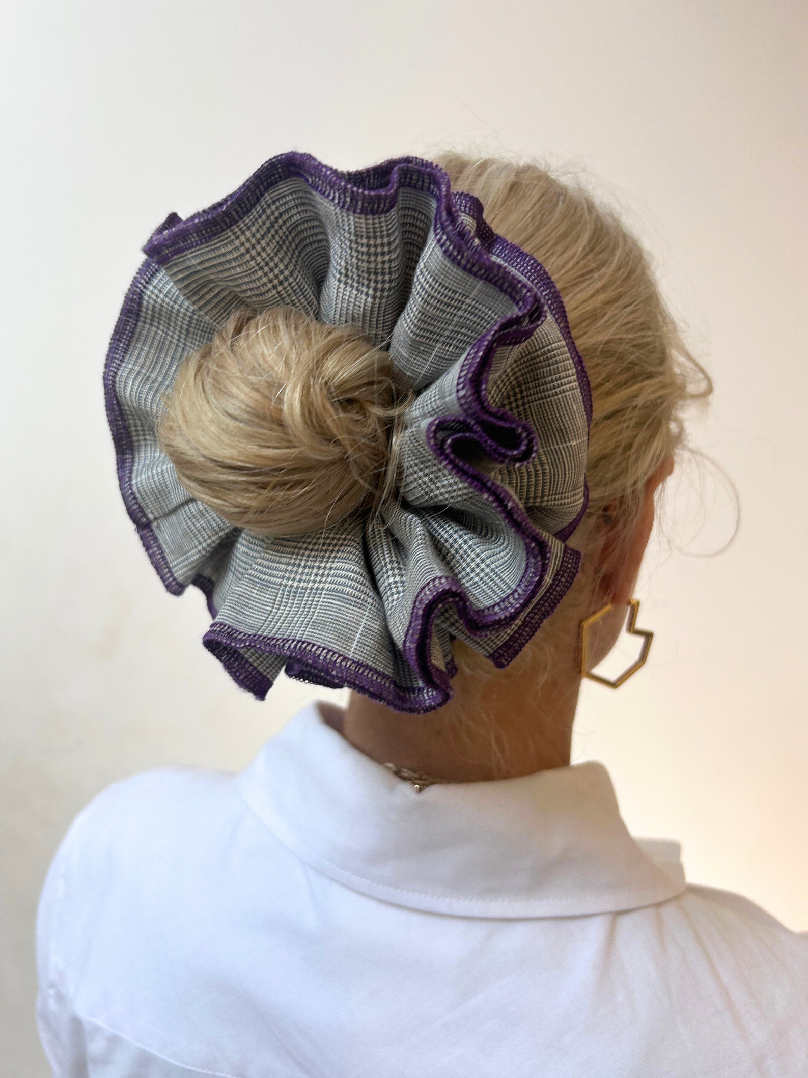 Woman wearing a decorative hair scrunchie with a white background