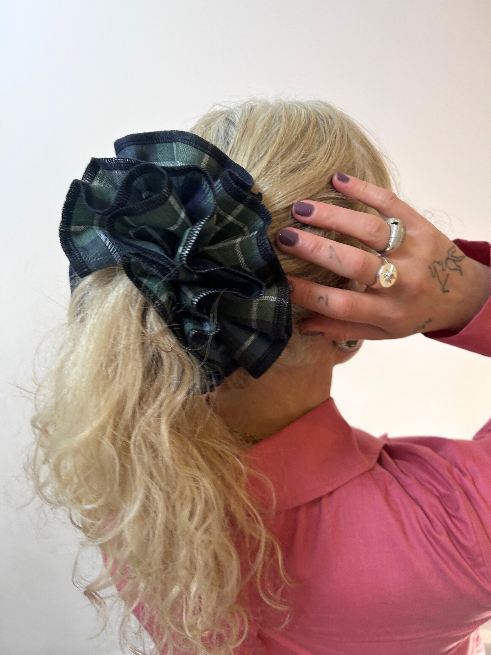 Person wearing a large plaid bow on their head against a white background