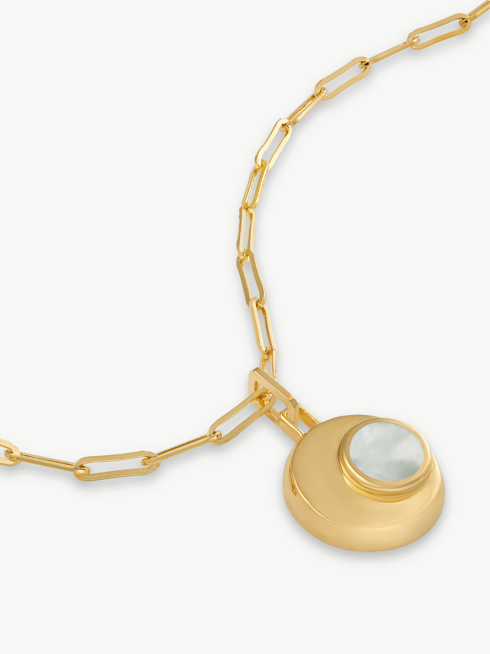 Gold necklace with a circular pendant on a white background