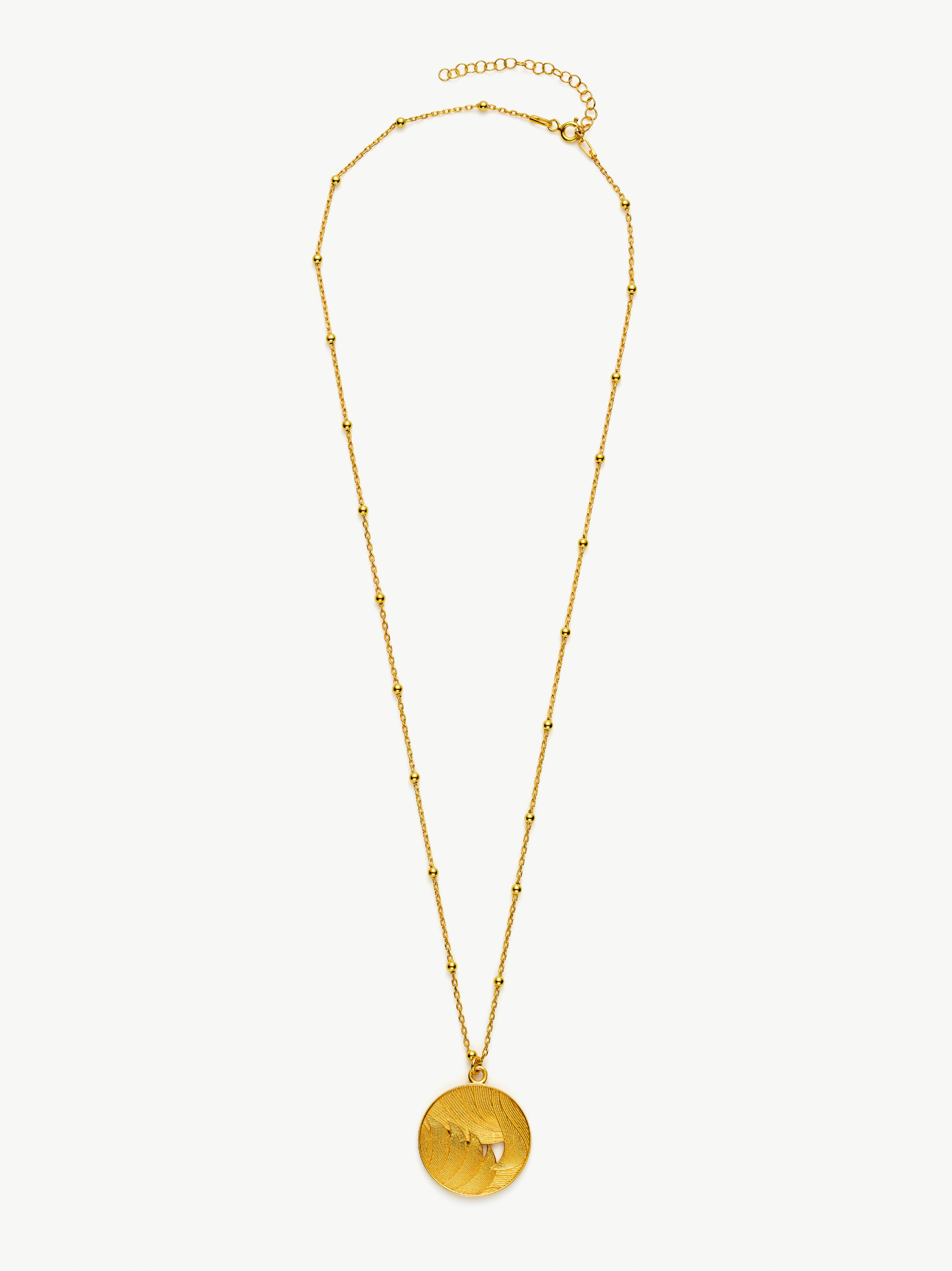 Gold necklace with a round pendant on a white background