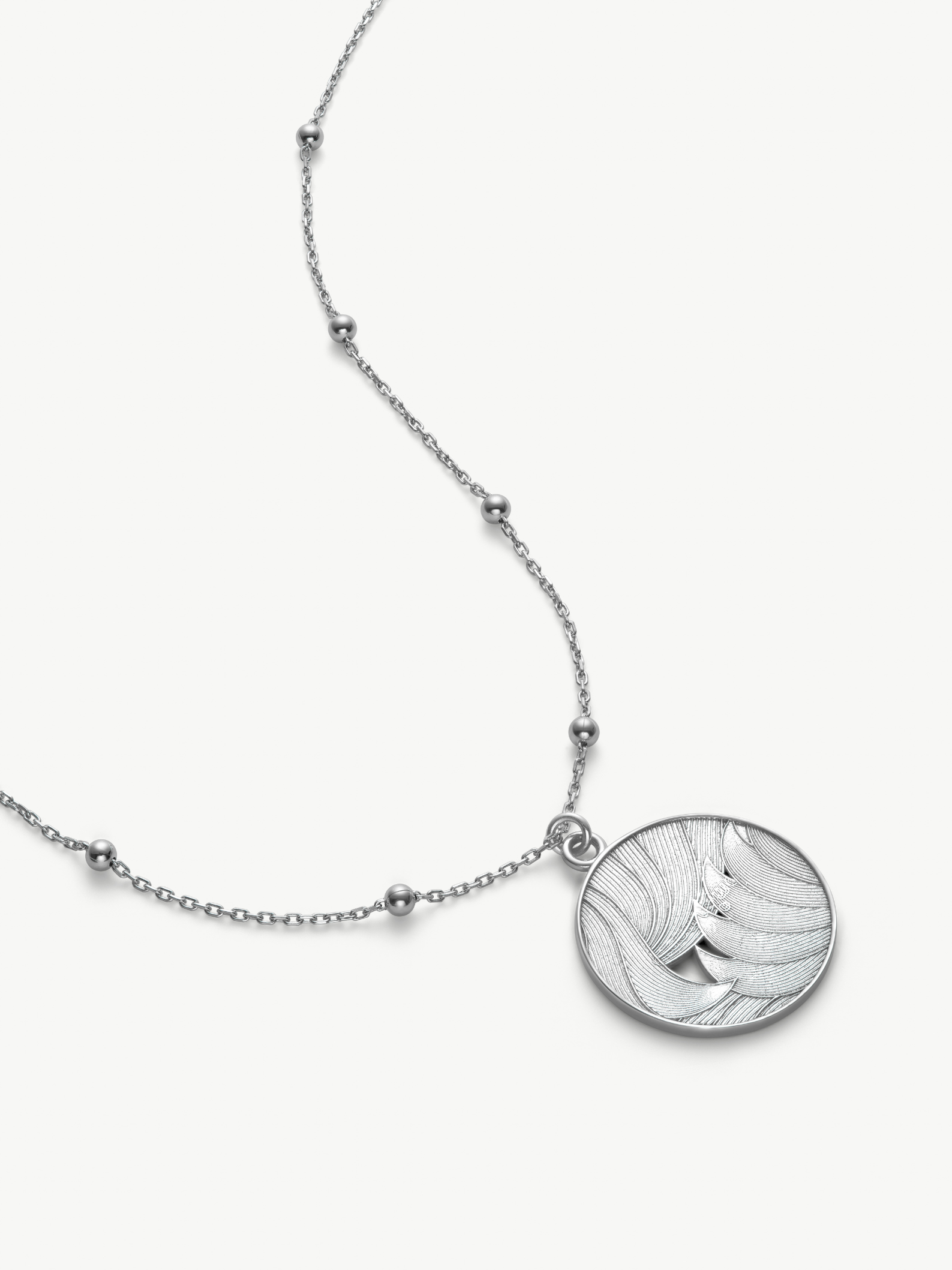 Silver necklace with a round pendant on a white background