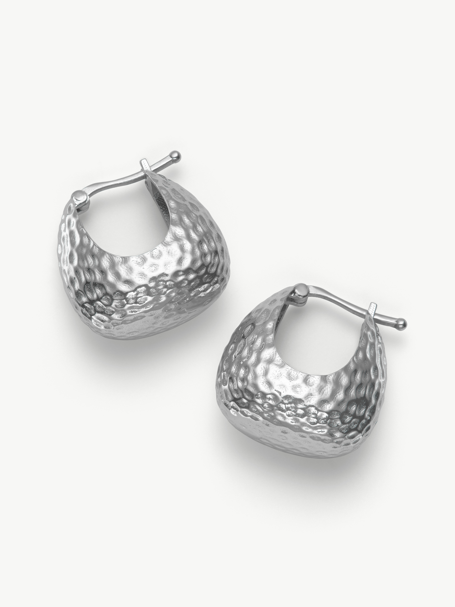 Pair of silver hoop hammered earrings on a white background