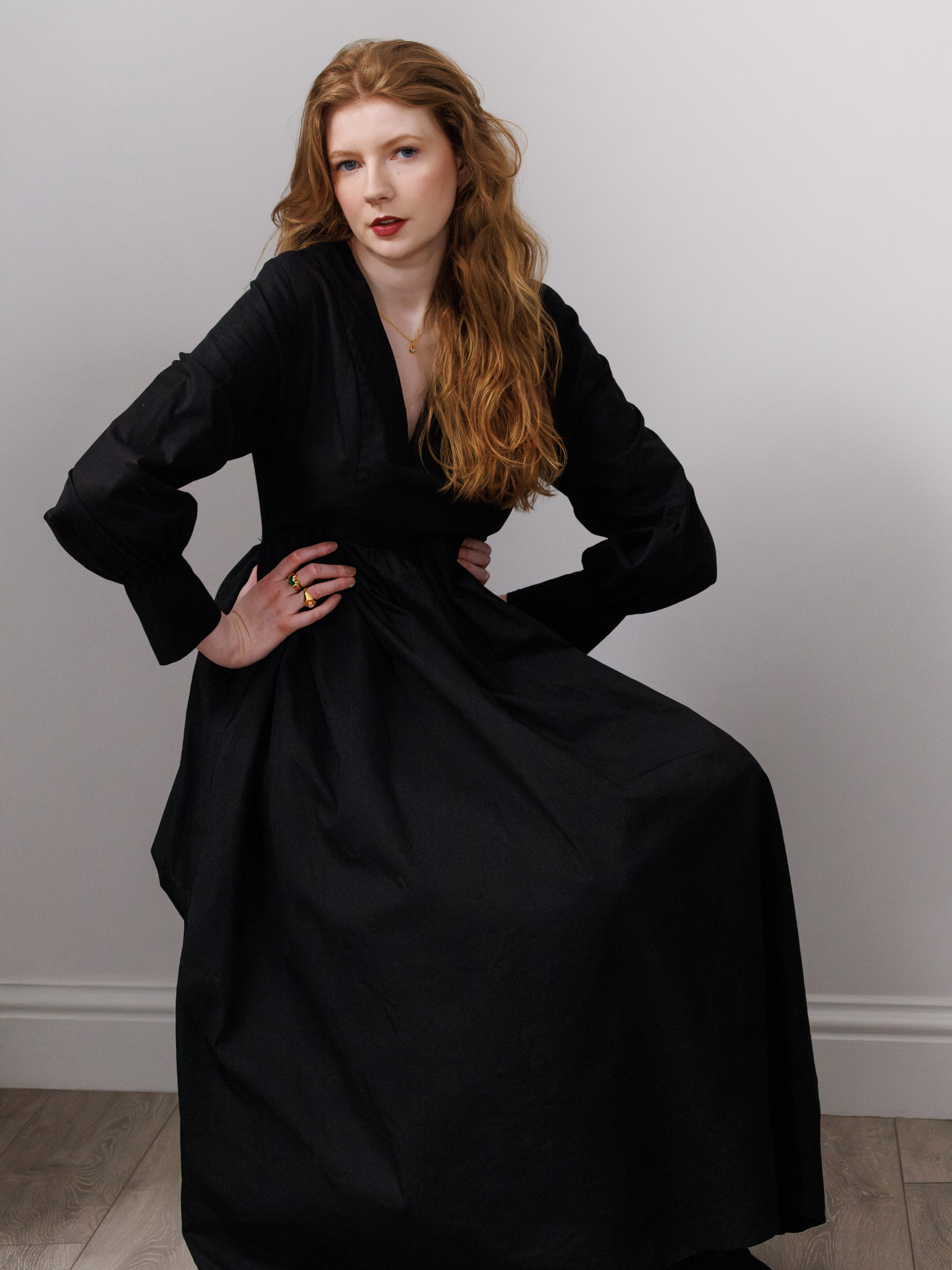 Woman wearing a black dress against a plain background