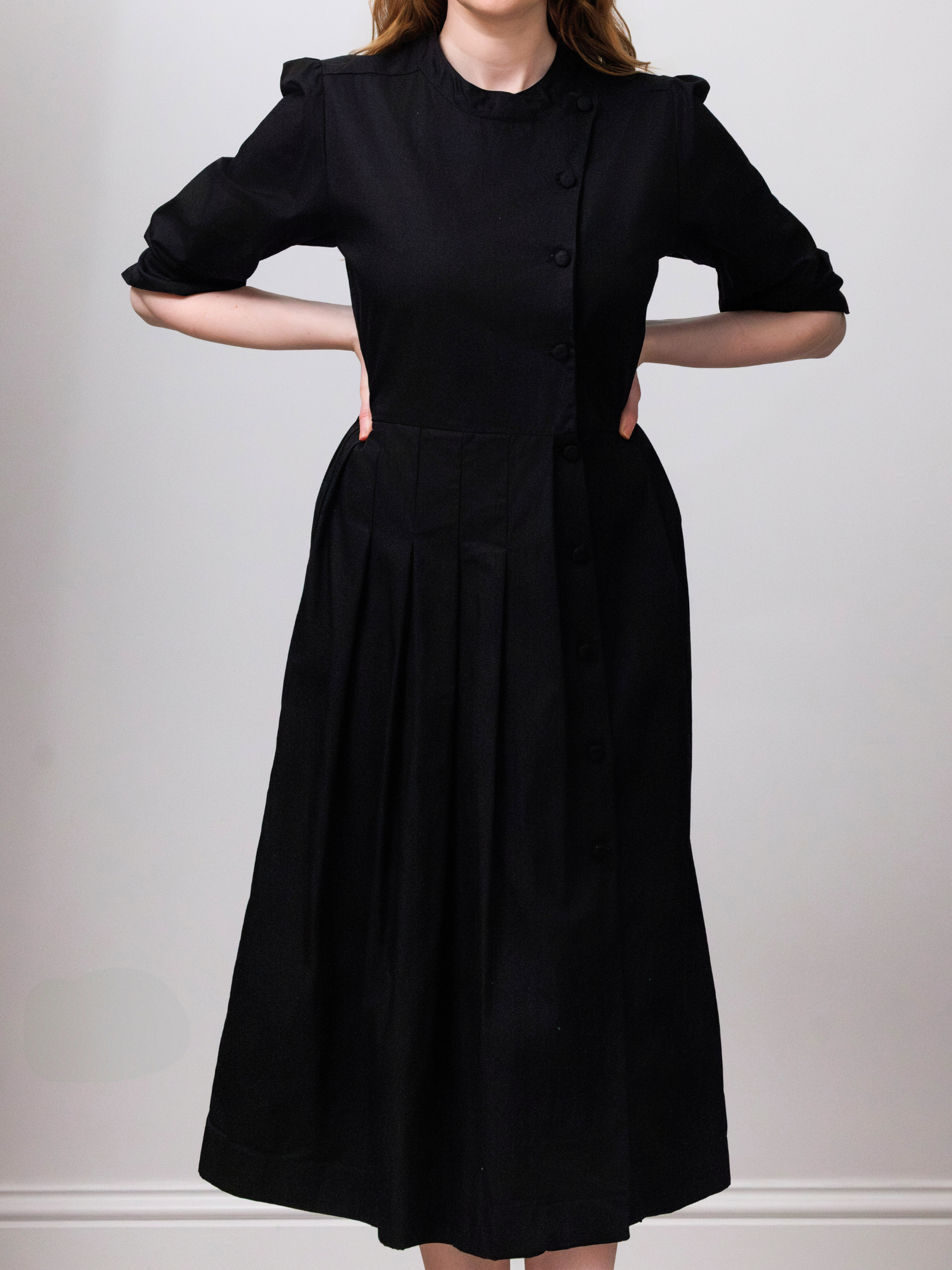 Person wearing a black dress with a white background