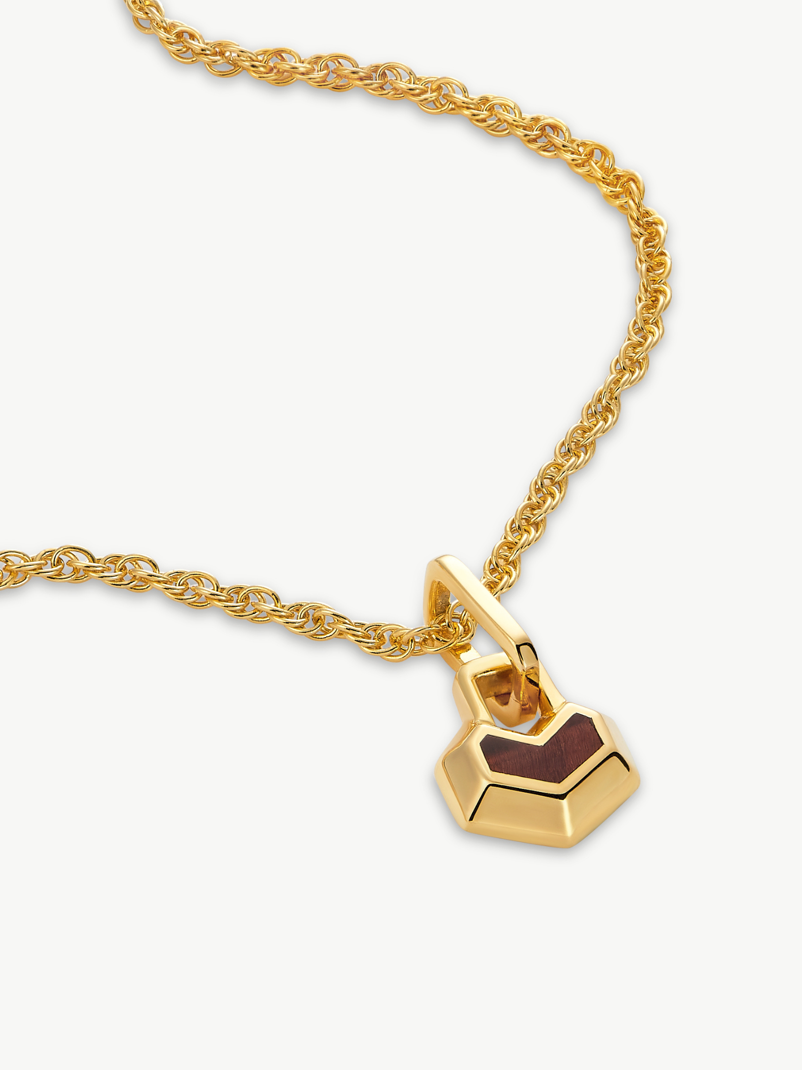 Gold necklace with a heart padlock pendant on a white background