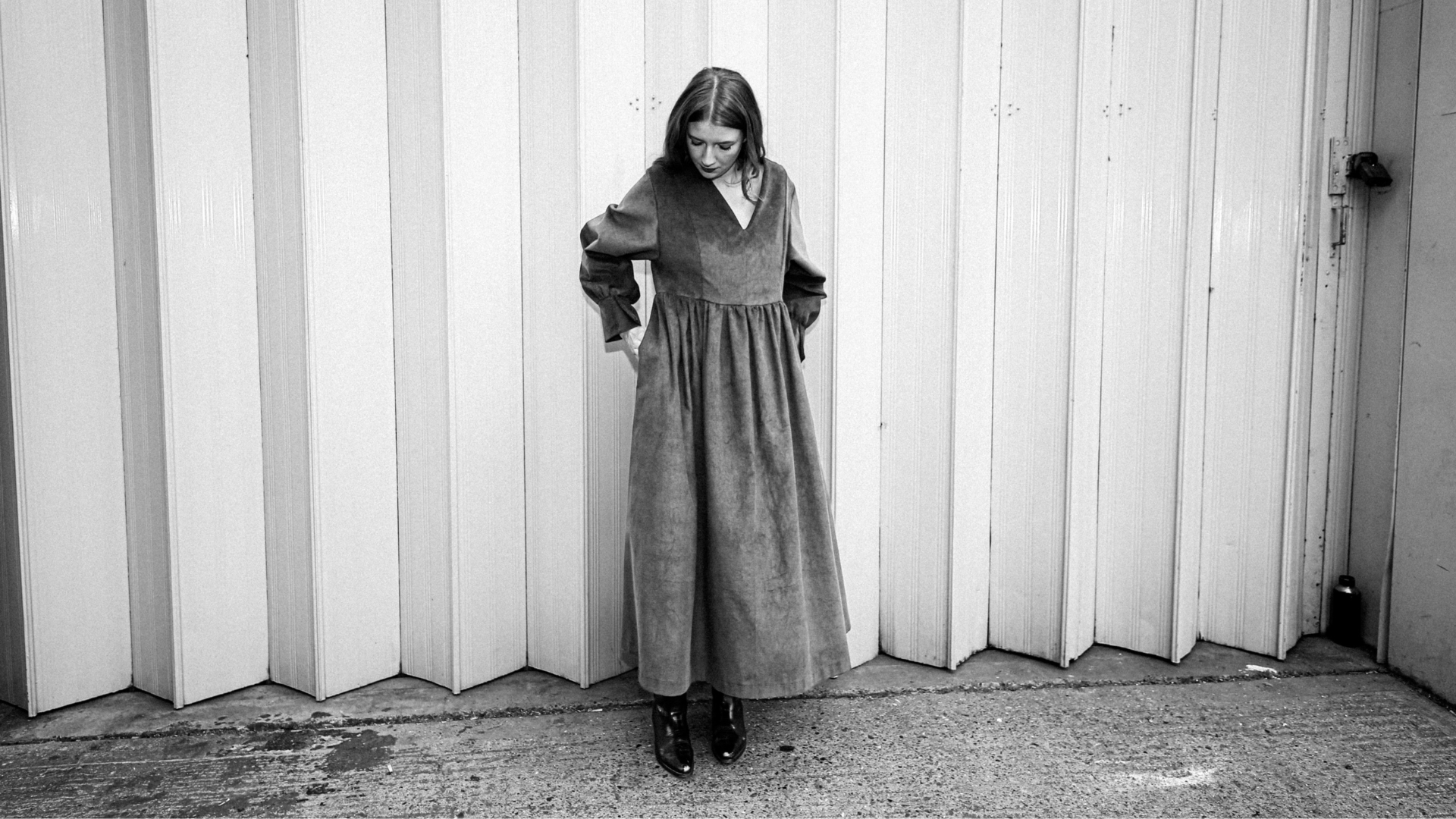 a woman wearing a dark dress in front of the white background