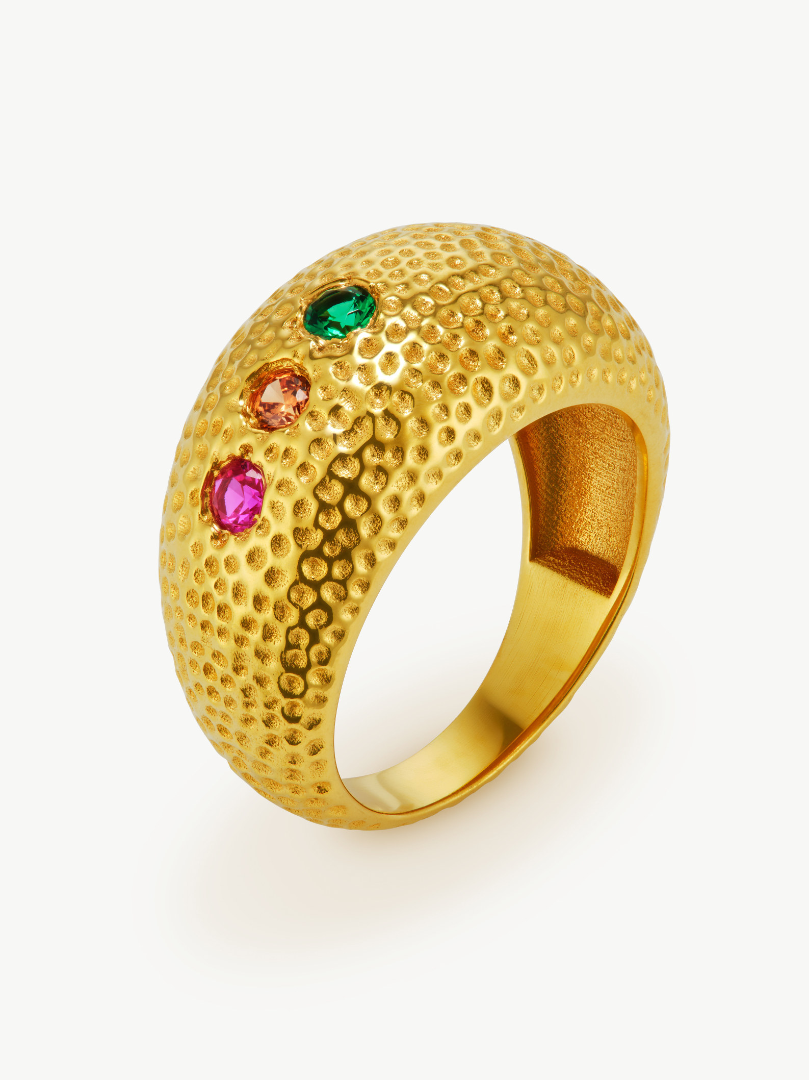 Gold ring with textured surface and colored gemstones on a white background