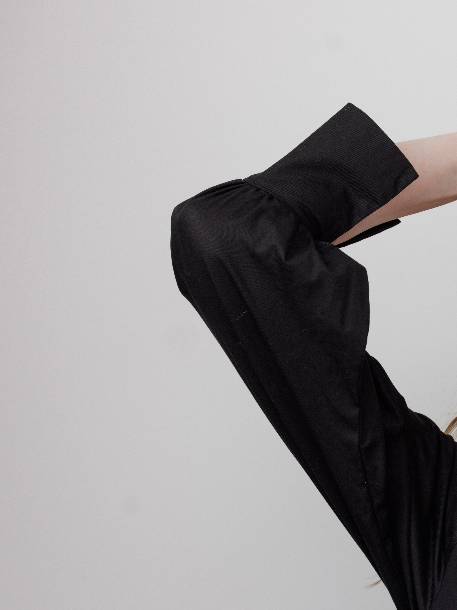 Black sleeveless top worn by a person on a light gray background