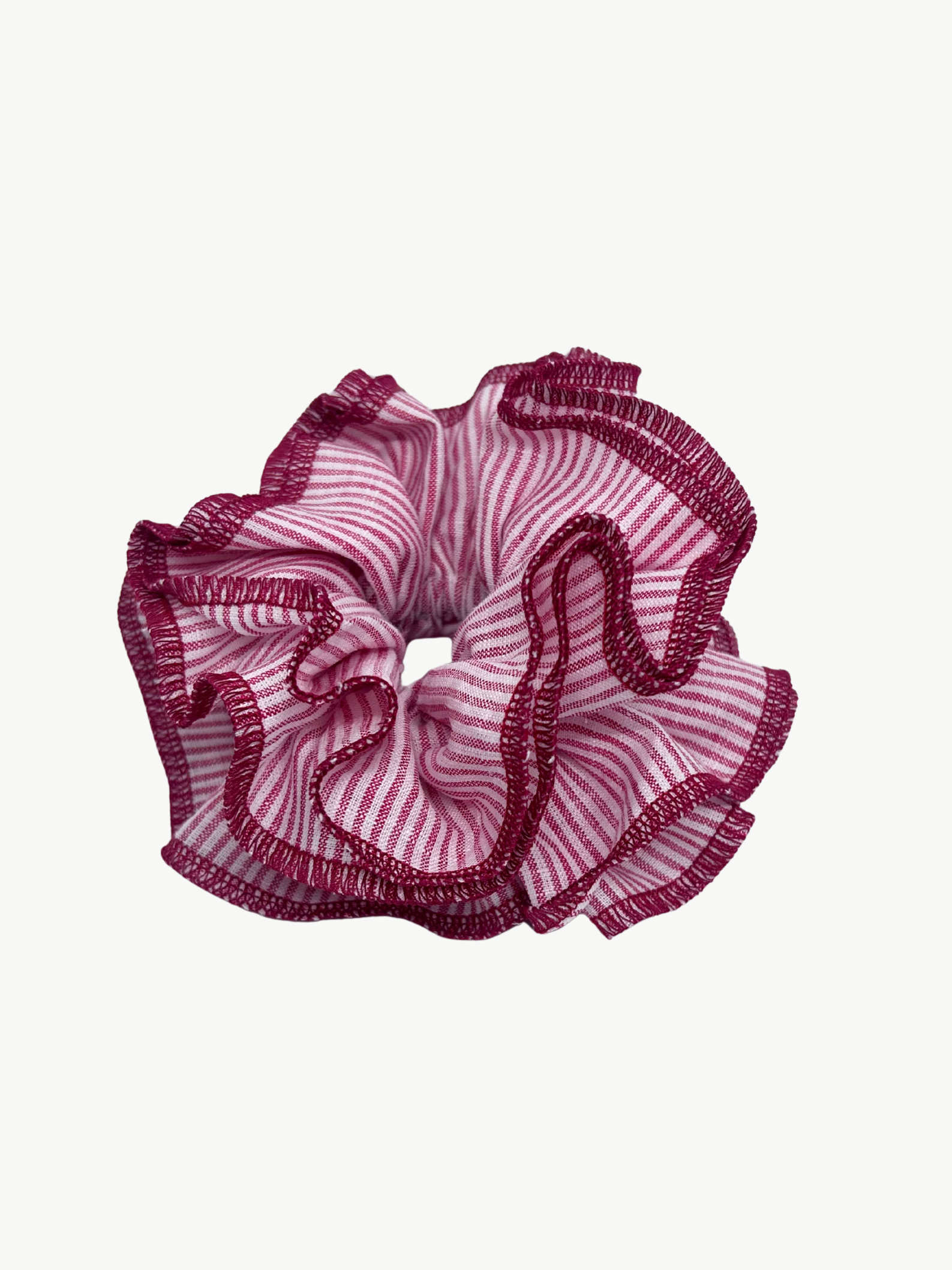 Pink scrunchie with ruffled edges on a white background