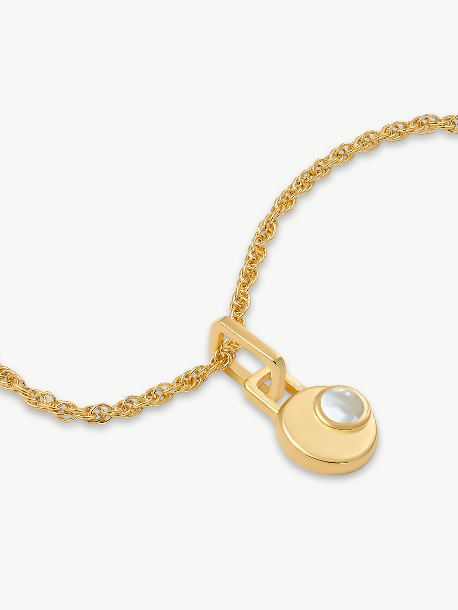 Gold necklace with a moon-phase pendant on a white background