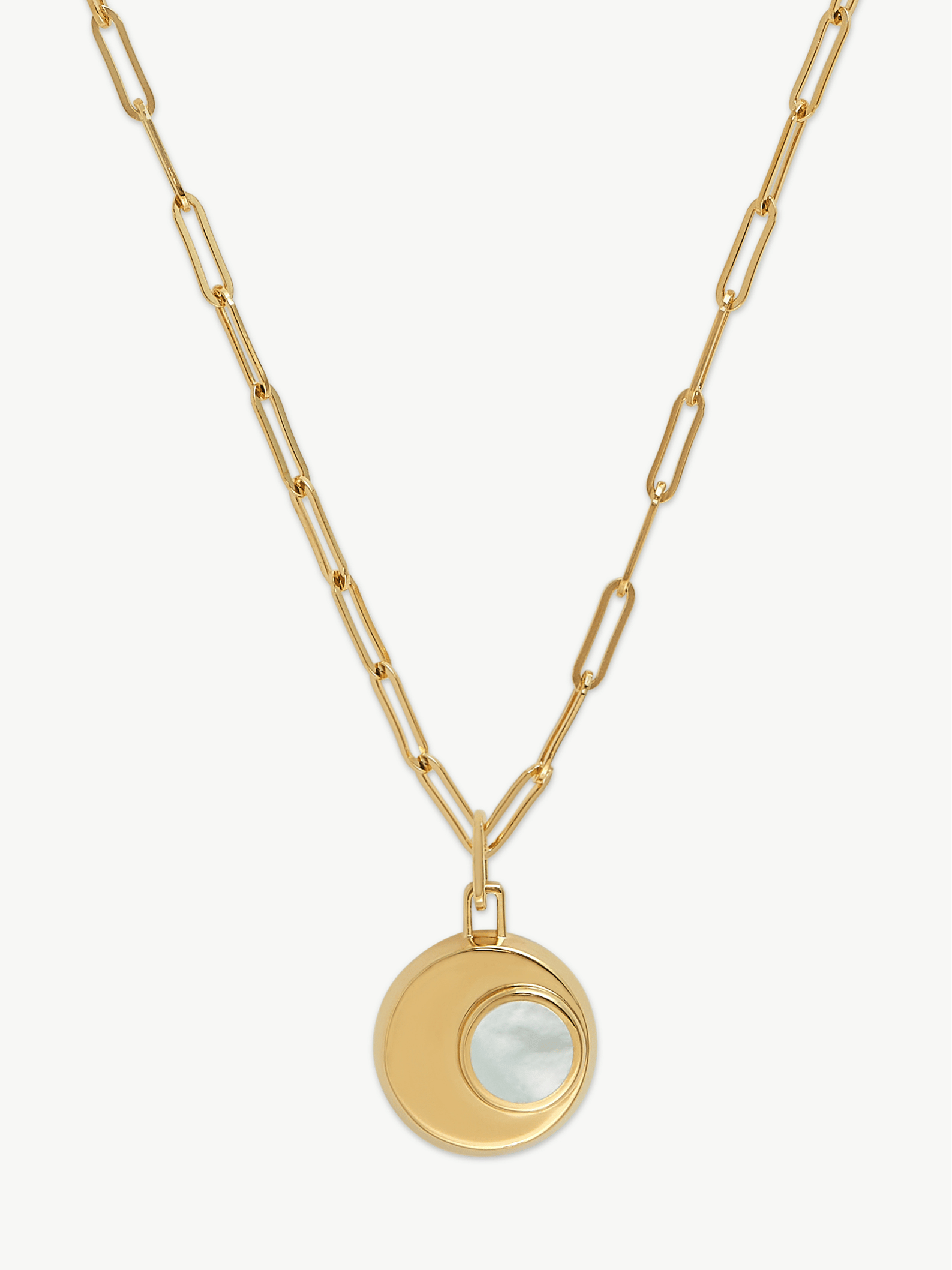 Gold necklace with a circular pendant on a white background