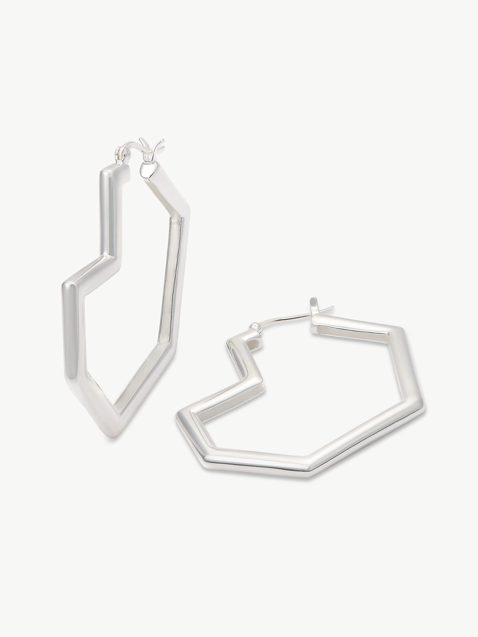 Silver geometric hoop earrings on a white background
