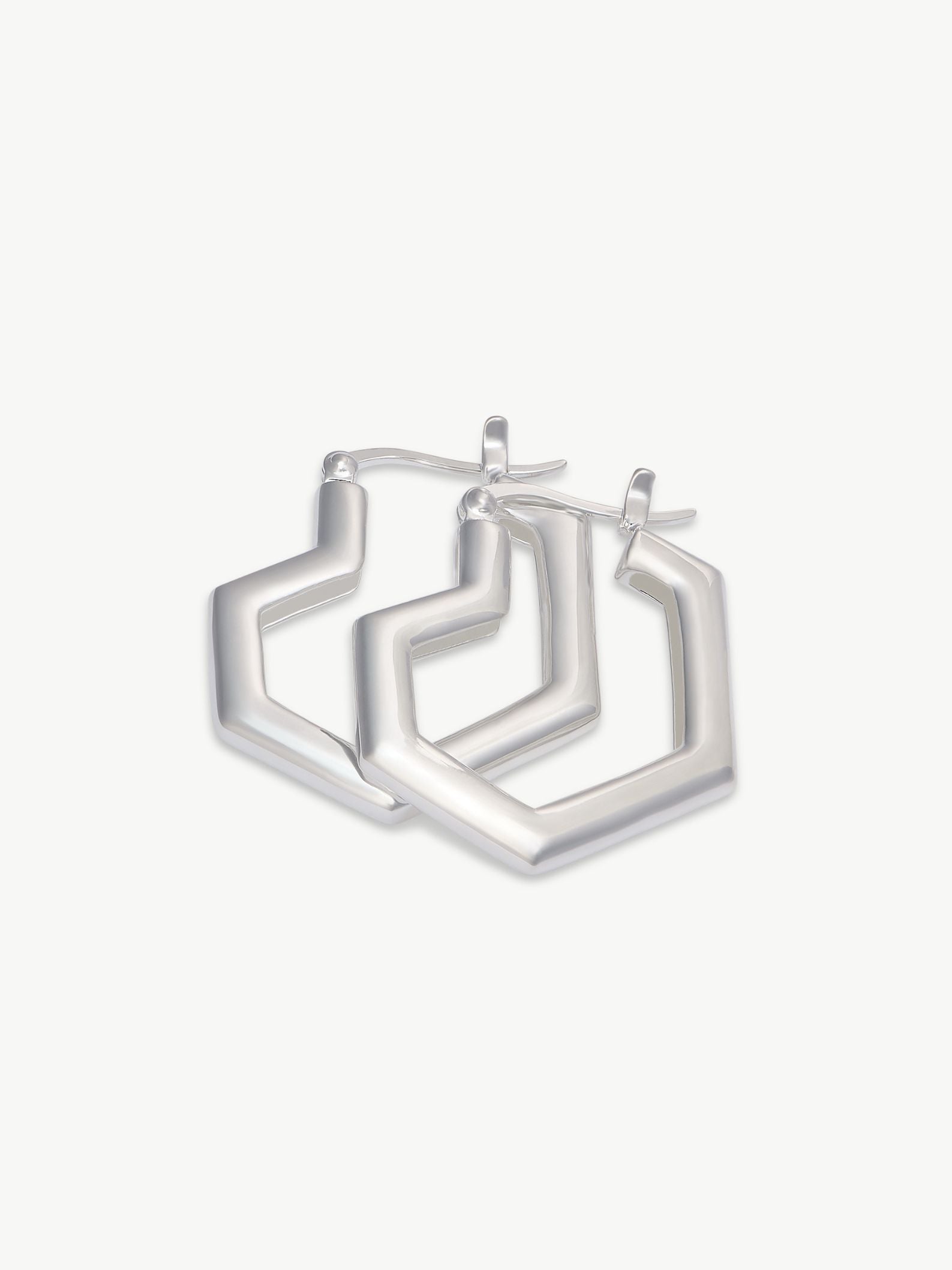 Set of silver hoop heart earrings on a white background