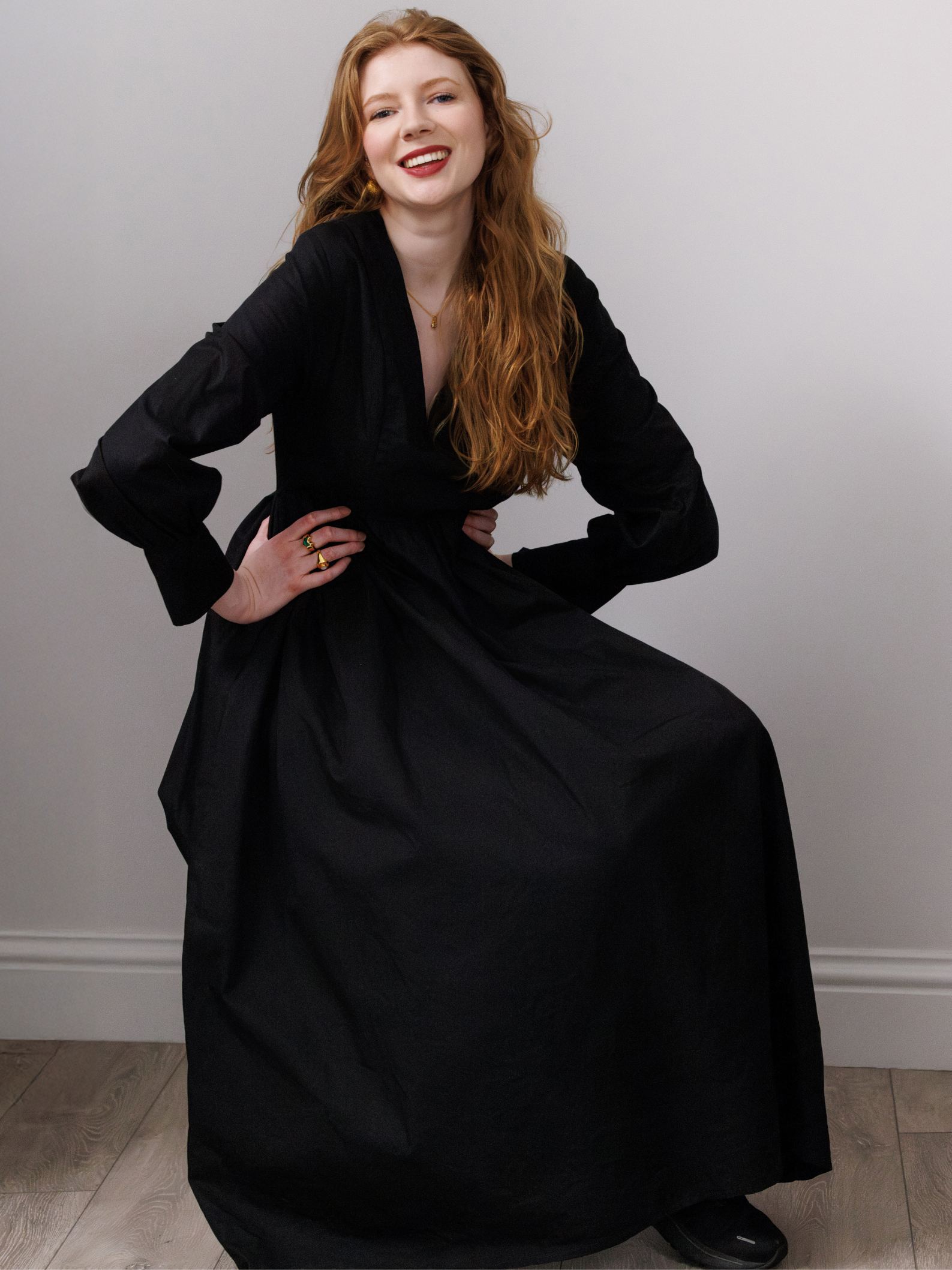 Woman wearing a black dress against a plain background