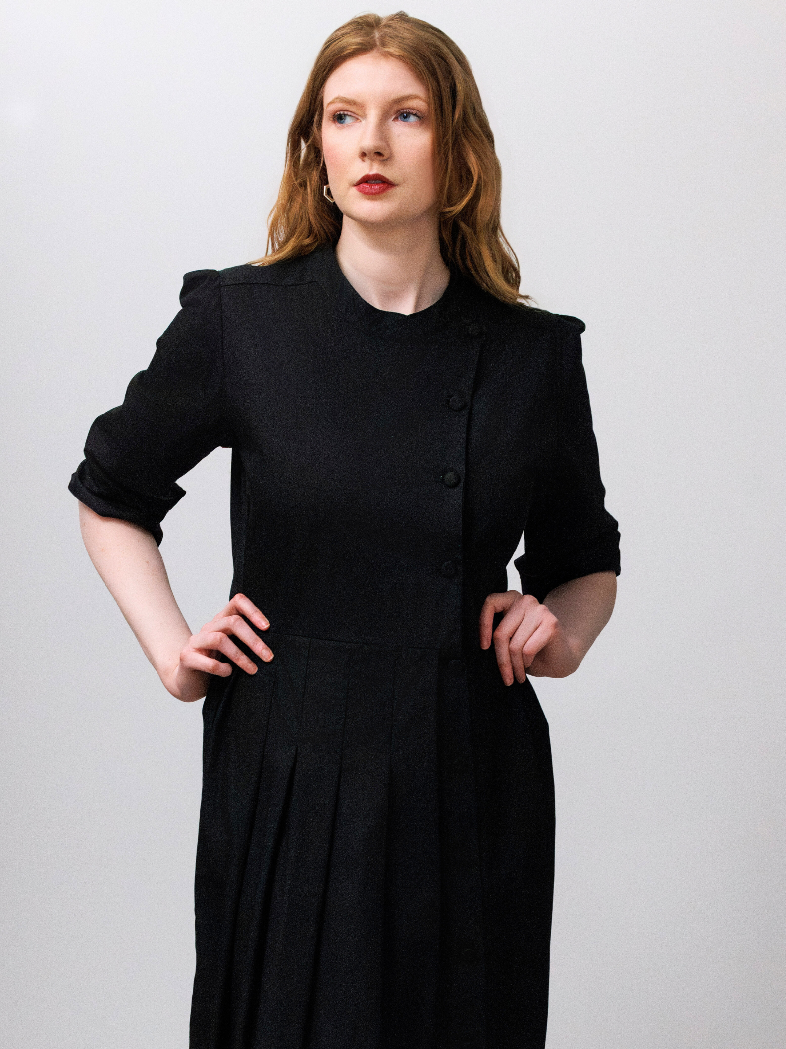Woman wearing a black dress against a plain background